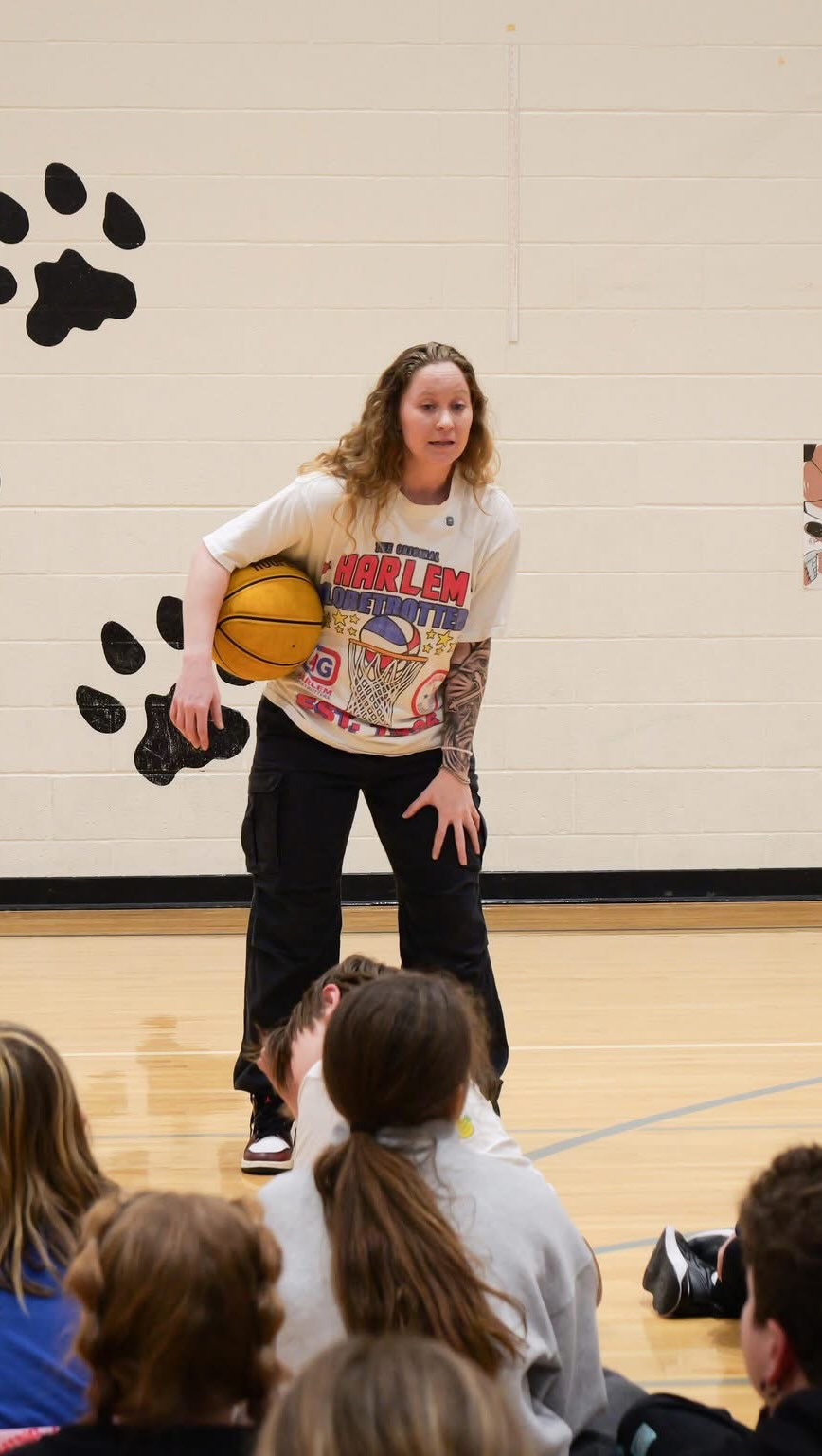 Hannah Mortimer in a Harlem Globetrotters shirt at a school gym visit