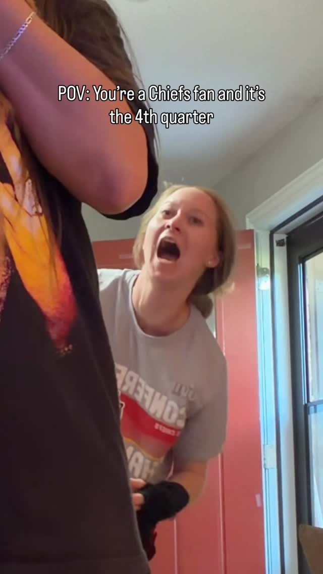 A woman reacts with her mouth open while looking at another person in a room
